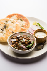 Pindi Chole Kulche or roadside choley Kulcha popular in India and pakistan is a popular streetfood. It's a spicy Chickpea or chana curry served with Indian Flat Bread. selective focus