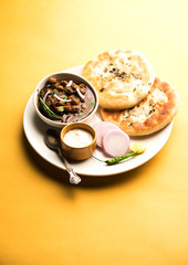Pindi Chole Kulche or roadside choley Kulcha popular in India and pakistan is a popular streetfood. It's a spicy Chickpea or chana curry served with Indian Flat Bread. selective focus