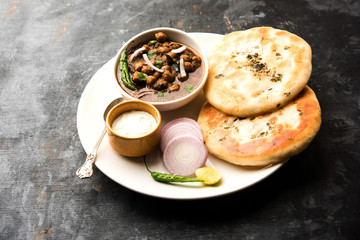 Pindi Chole Kulche or roadside choley Kulcha popular in India and pakistan is a popular streetfood. It's a spicy Chickpea or chana curry served with Indian Flat Bread. selective focus