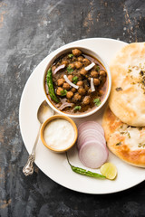 Pindi Chole Kulche or roadside choley Kulcha popular in India and pakistan is a popular streetfood. It's a spicy Chickpea or chana curry served with Indian Flat Bread. selective focus