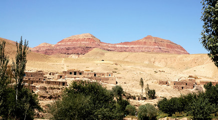 Village between Herat and Qala-e-Naw, Herat Province in Afghanistan with a backdrop of colorful red...