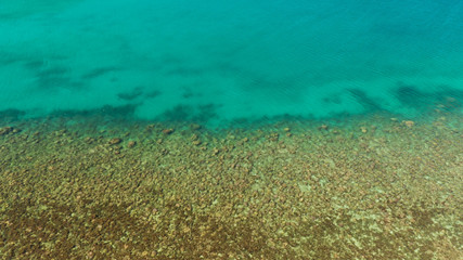 Naklejka na ściany i meble Aerial view clean sea surface copy space for text. Sea water surface in lagoon. Top view transparent turquoise ocean water surface. sea bottom with stones