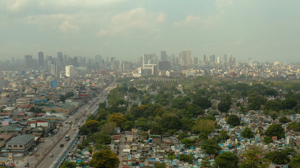 Aerial view of panorama of Manila North Cemetery with skyscrapers and business centers in a big city. Travel vacation concept