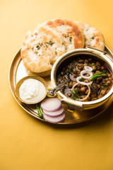 Pindi Chole Kulche or roadside choley Kulcha popular in India and pakistan is a popular streetfood. It's a spicy Chickpea or chana curry served with Indian Flat Bread. selective focus