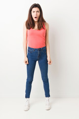 Full body young woman on white background screaming very angry and aggressive.