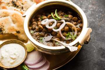 Pindi Chole Kulche or roadside choley Kulcha popular in India and pakistan is a popular streetfood. It's a spicy Chickpea or chana curry served with Indian Flat Bread. selective focus