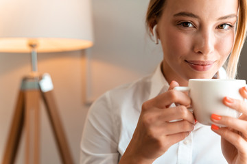 Business woman using wireless bluetooth earphones.