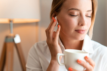 Business woman using wireless bluetooth earphones.