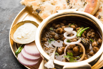Pindi Chole Kulche or roadside choley Kulcha popular in India and pakistan is a popular streetfood. It's a spicy Chickpea or chana curry served with Indian Flat Bread. selective focus