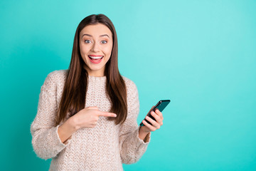 Portrait of cheerful astonished girl point at her cell phone red news scream wow omg have like in...