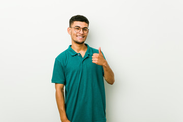 Young hispanic man smiling and raising thumb up