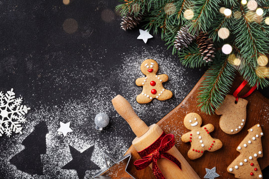 Christmas baking background. Gingerbread cookies, rolling pin and fir tree top view. Homemade sweet pastries for winter holidays.