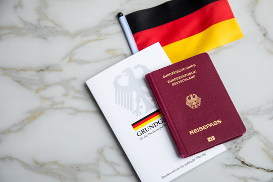 Hamburg, Hamburg/Germany – 09-23-2019: Reisepass und Grundgesetz Buch der Bundesrepublik Deutschland mit Flagge auf Marmor Hintergrund