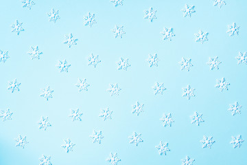 Winter pattern made of white snowflakes on blue background. Top view. Flat lay. Winter composition. Christmas, new year concept.