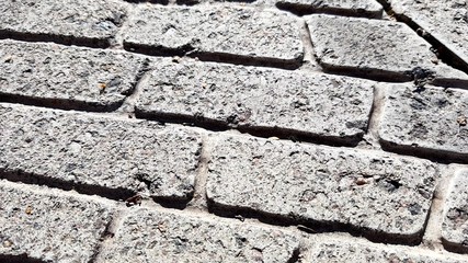 old stone tiled floor with round pattern on a sunny street, review.