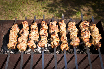 Kebab grilling on metal skewers. Meat on the grill. Close up.