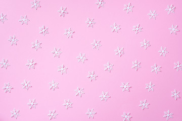 Winter pattern made of white snowflakes on pink background. Top view. Flat lay. Winter composition. Christmas, new year concept.