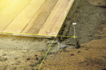 Check the level in the tiling outdoor around the house by hit nail on floor and stretch rope for align tile to match.