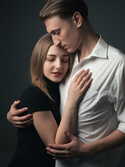 Young passionate couple in love hugging in studio.