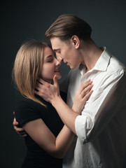 Young passionate couple in love posing in studio.