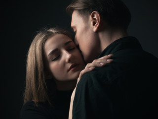Portrait of passionate young couple in love. Close up. Low key