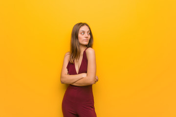 Obraz premium Young natural woman wearing a red dress against an orange wall