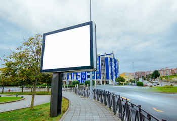 Blank advertising billboard in the city and car traffic in motion