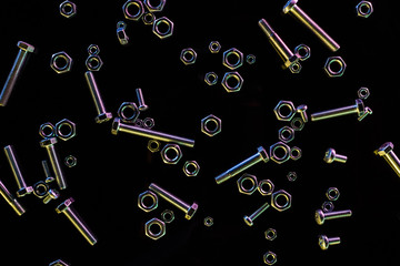 top view of scattered various bolts and nuts isolated on black