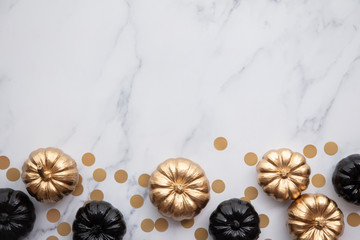 Luxury gold and black autumn pumpkin flat lay composition on a marble background