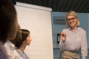Young employees listening business coach middle aged lady during seminar