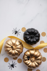 Obraz na płótnie Canvas Luxury gold and black autumn pumpkin flat lay composition on a marble background
