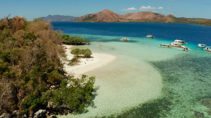 aerial seascape tourists enjoy tropical beach. tropical island with sand beach CYC, palm trees. Philippines, Palawan. Tropical landscape with blue lagoon, coral reef