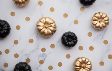 Luxury gold and black autumn pumpkin flat lay composition on a marble background