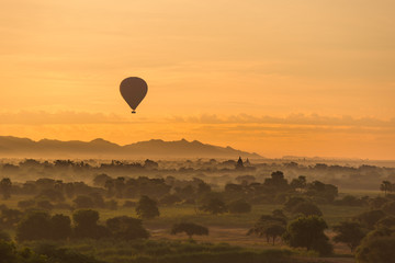 Sunrise over Bagan with Balloon at a foggy sky, Myanmar temples in the Archaeological Park