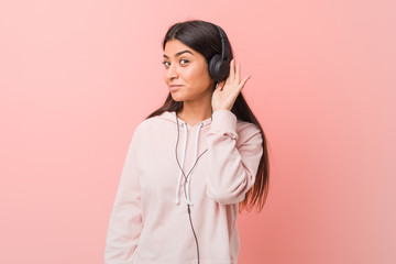 Young arab woman listening to music trying to listening a gossip.