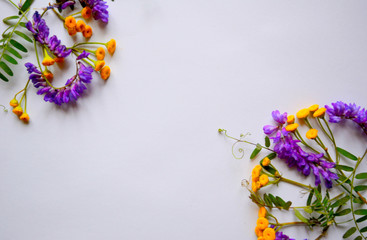 Festive beautiful composition of purple and yellow flowers and green leaves on a white background. Flat lay. Top view. Copy space.