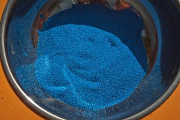 Blue ink in powder form. Texture of fine powder in a metal bowl. Paint for children's creativity.