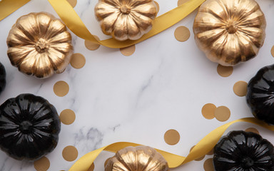 Luxury gold and black autumn pumpkin flat lay composition on a marble background