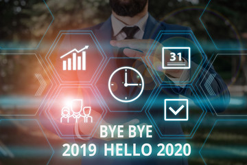 Word writing text Bye Bye 2019 Hello 2020. Business photo showcasing Starting new year Motivational message 2019 is over Male human wear formal work suit presenting presentation using smart device © A
