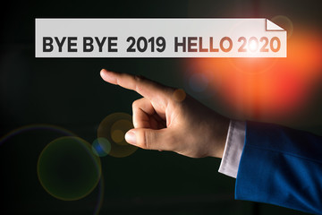Writing note showing Bye Bye 2019 Hello 2020. Business concept for Starting new year Motivational message 2019 is over Isolated hand pointing with finger. Business concept pointing finger © A