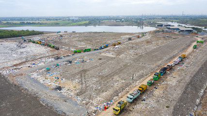 Garbage trucks unload garbage to open landfill, Surface and subsurface water contamination, modern...