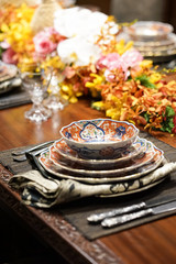 Vintage crockery. Dining table with vintage setting arrangement and beautiful dishes and other stainless utensils.