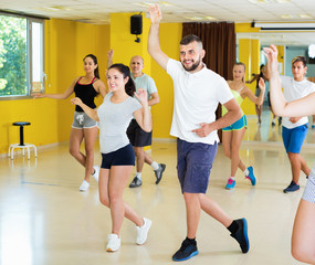 Positive people exercising in dance hall