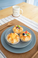 A blue plate of fruit buns on the table -squishy