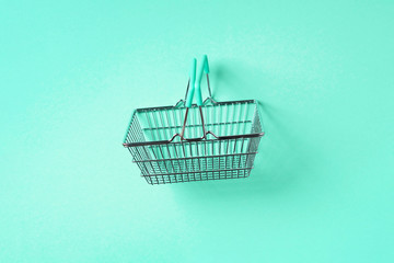 Top view of supermarket shopping basket on trendy green background. Black friday sale concept. Copy...