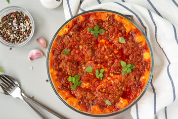 Traditional dish casserole with meat, potatoes, cheese and tomatoes. Close up, top view. 