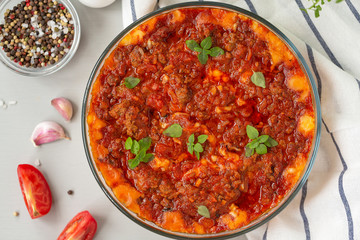 Traditional dish casserole with meat, potatoes, cheese and tomatoes. Close up, top view. 