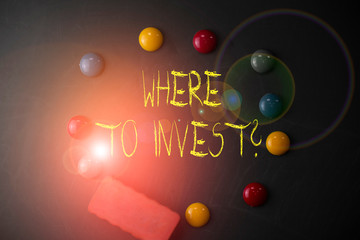 Word writing text Where To Invest Question. Business photo showcasing asking someone about place to put money into Round Flat shape stones with one eraser stick to old chalk black board