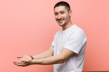 Young casual man holding a copy space on a palm.