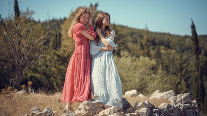 Portrait of two girls in dresses on the nature